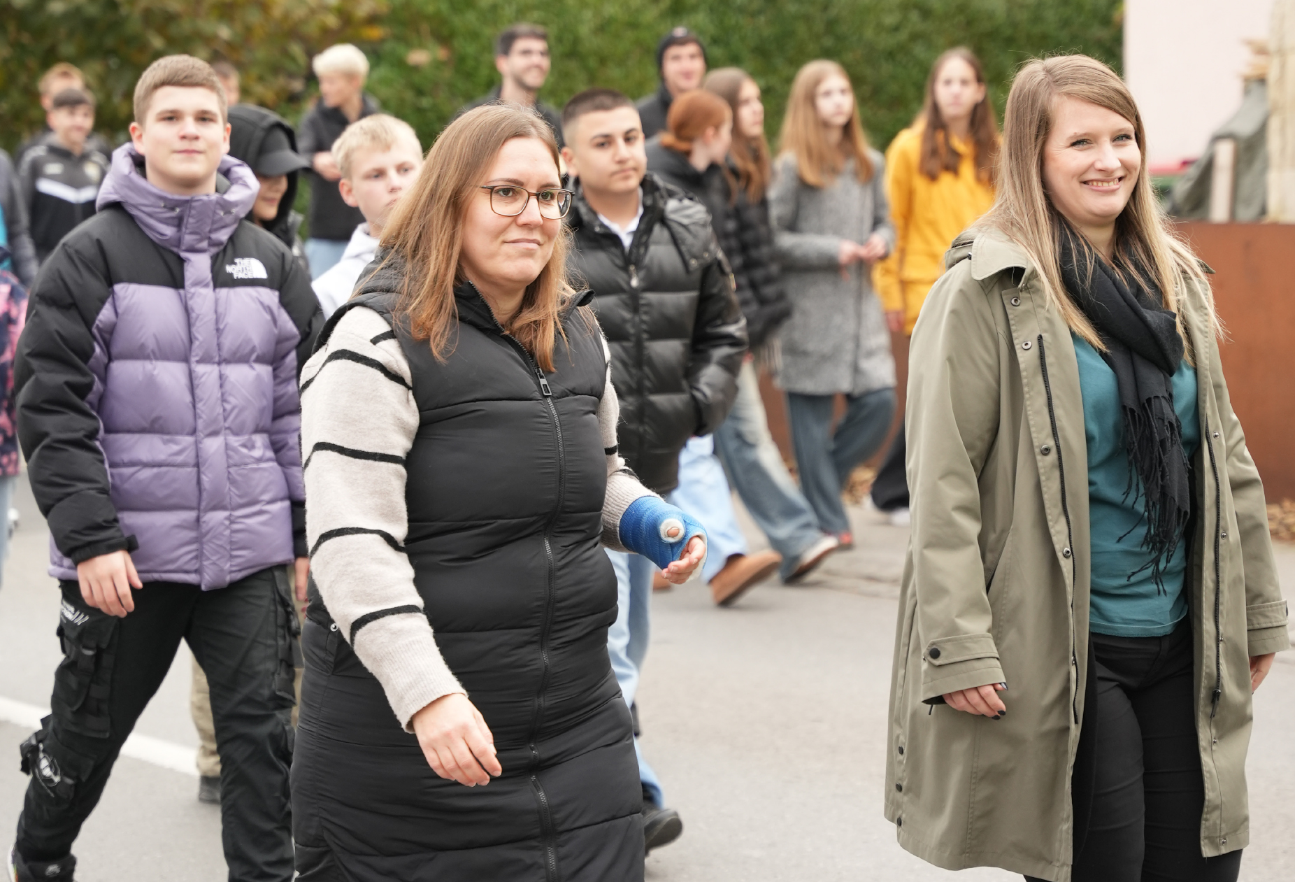 Zwei Mitarbeiterinnen und Schüler im Hintergrund