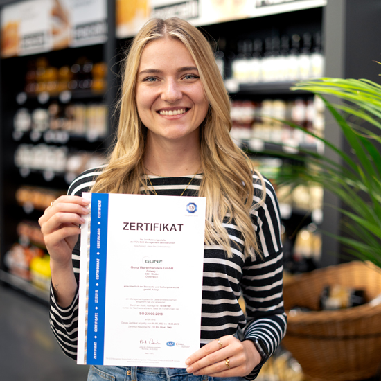 Gunz employee holds ISO certificate in front